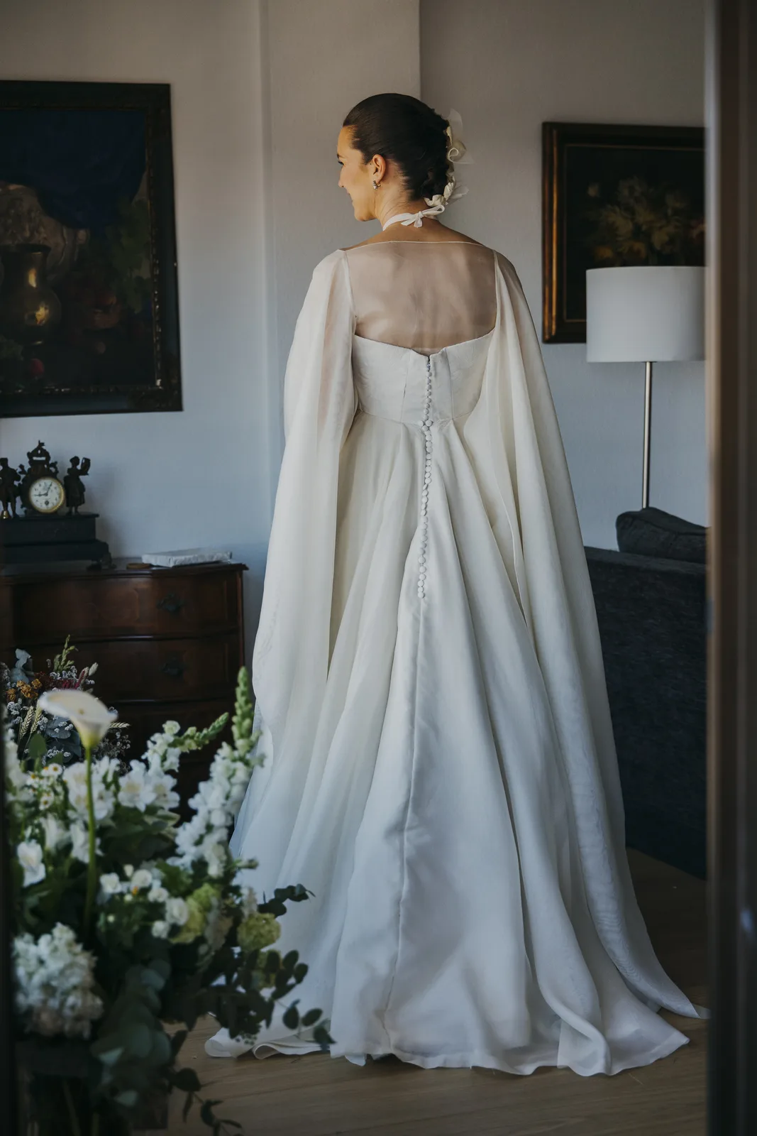 Espalda del vestido de novia con capa y botonadura