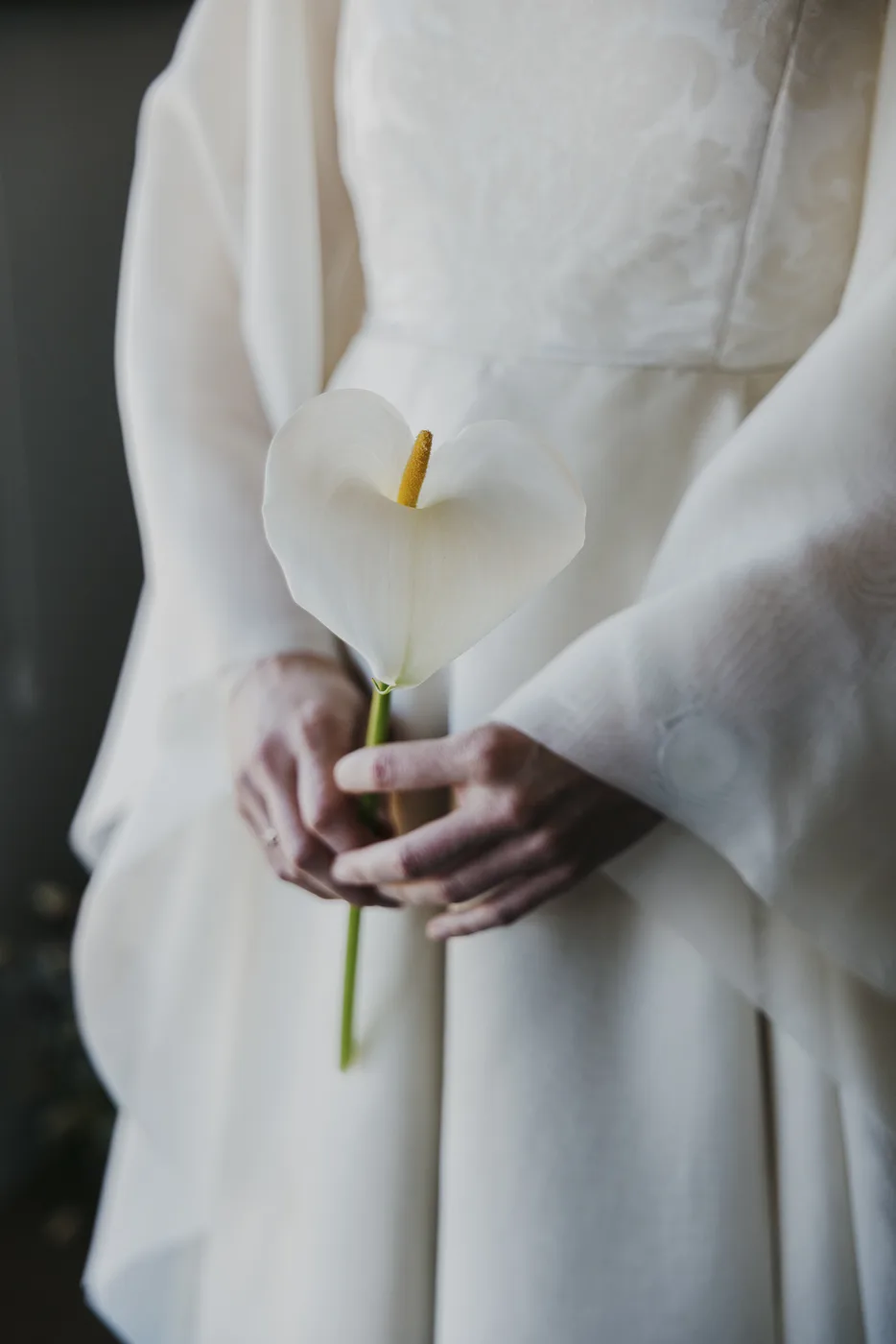 Detalle de las manos de la novia sosteniendo una cala